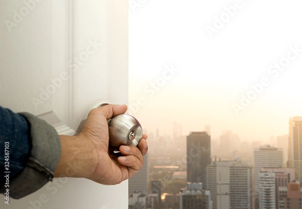 Fototapeta Hand open the door to find city view.Explorer for opportunity and successful concept.