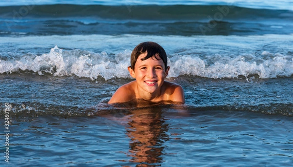 Obraz Child has fun and relaxes with the waves of the sea.