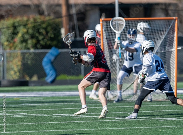 Fototapeta Young athletes making amazing plays while playing in a Lacrosse game