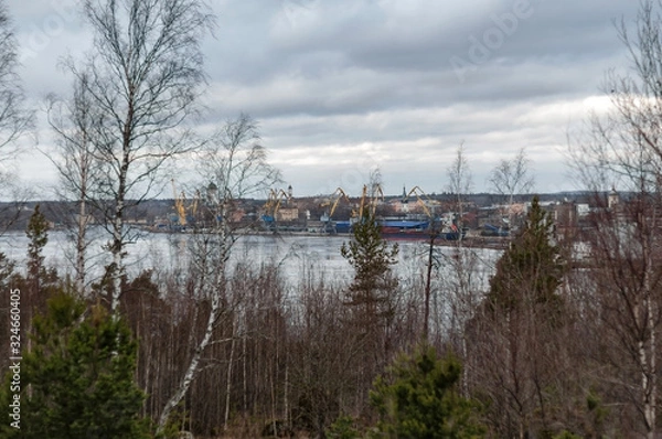 Fototapeta View from the shore of the bay to the ancient city of Vyborg and the port on a cloudy spring day