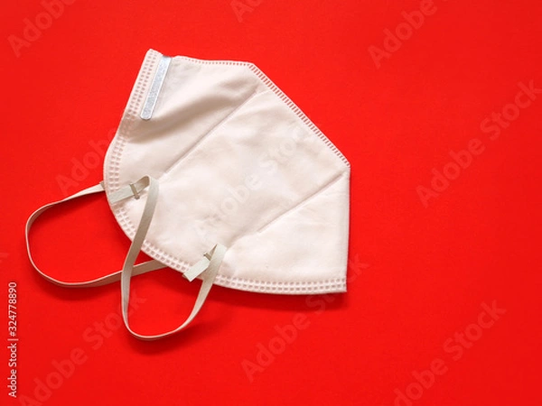Fototapeta Protective face mask on red background. Top view with copy space. Health care and Medical concept..