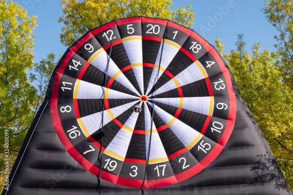 Fototapeta Giant inflatable dart board with velcro ball in autumn park.