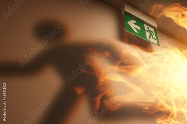 Fototapeta the shadow of an escaping man and a fire in the building
