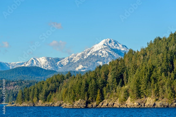 Fototapeta Fantastic view over ocean, snow mountain and rocks at Sechelt inlet in Vancouver, Canada.