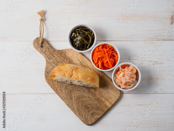 Fototapeta Different salads on white wooden background.