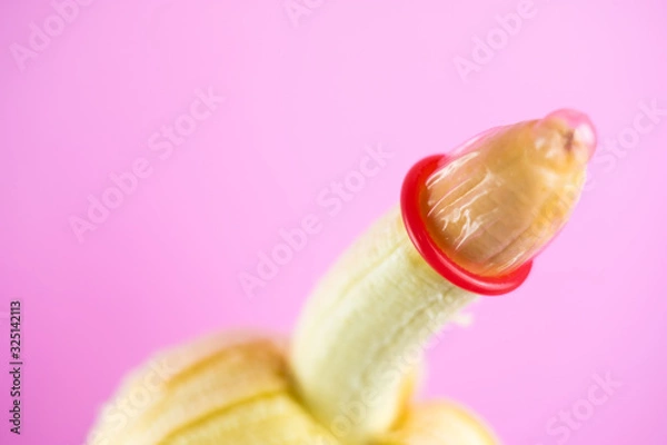 Obraz closeup condom on banana with pink background (World AIDS Day concept), soft focus.