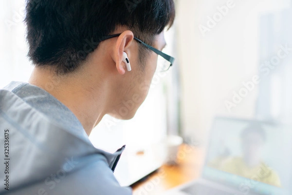 Obraz 部屋着でリモートワークする会社員男性