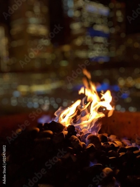 Obraz Flickering fire at night with blurry city background Chicago 