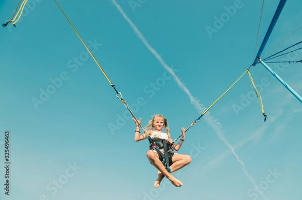 Fototapeta child jumping in the jumping attraction