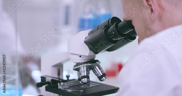 Fototapeta Close-up of a microscope and a working man