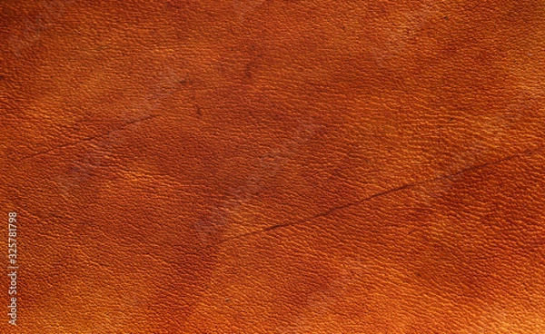 Fototapeta Orange nut brown vegetable tanned leather closeup full frame macro texture showing top grain and wear scratch marks