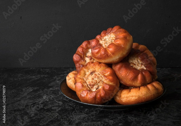 Fototapeta Fried peremyachi, belyashi, pies on a black background. Traditional Russian pies. Russian, Bashkir and Tatar cuisine. Copy space.