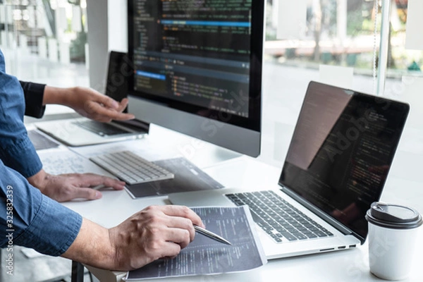 Fototapeta Team of developer programmer working on project in software development computer in IT company office, Writing codes and data code website and coding database technologies to find problem solution