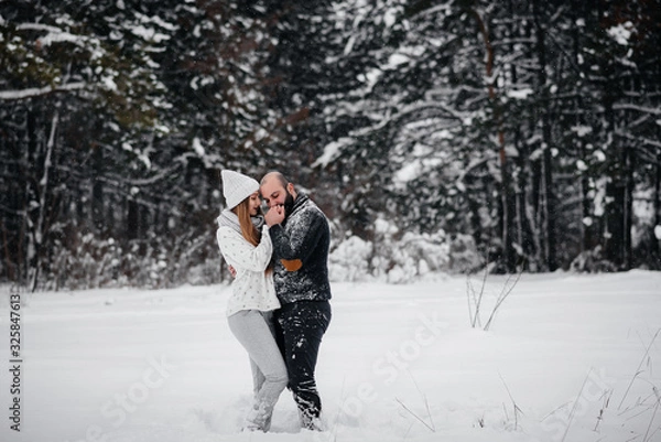 Fototapeta Couple playing with snow in the forest