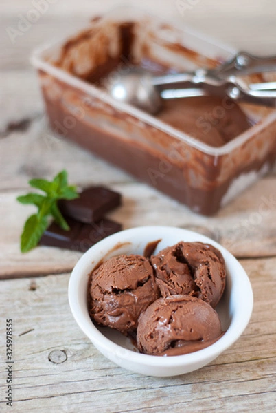 Obraz White bowl with three balls of homemade chocolate ice cream on a wooden table