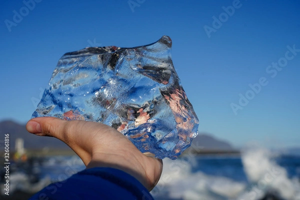 Fototapeta tourist hand holding crystal ice at diamond beach Iceland 