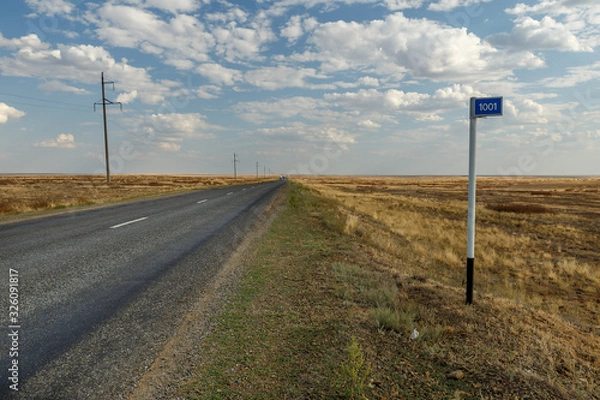 Fototapeta empty road in the steppe and kilometer sign 1001, Kazakhstan, Ayteke Bi District, Highway M32