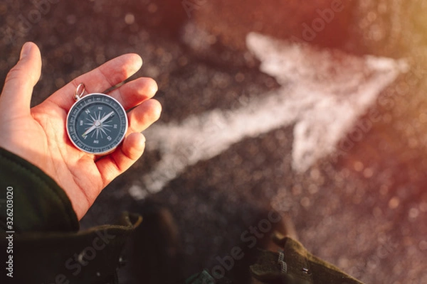Fototapeta Hipster traveler holding compass in the hand making choice in what direction to go