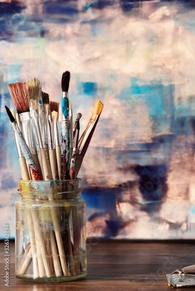 Obraz Paint brushes and abstract artwork on canvas