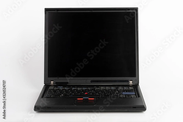 Fototapeta Old laptop on white background, which was produced in 2005, outer cover reinforced titanium, metal hinges, red trackpoint.