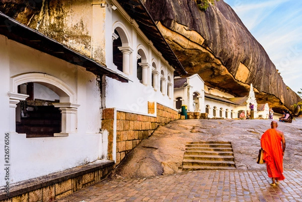 Fototapeta A buddhist monk is walking along the Rock cave temple , a world heritage site in Dambulla,  Sri Lanka