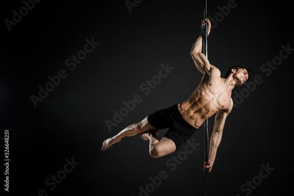 Obraz Portrait of male model performing a pole dance