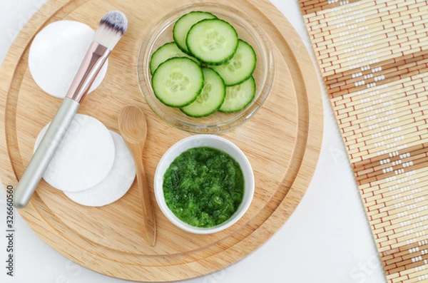 Obraz Fresh cucumber puree, cucumber slices, cotton pads and cosmetic brush. Ingredients for preparing homemade mask. Natural beauty treatment recipe and zero waste concept. Top view, copy space.  