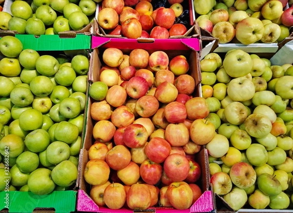Fototapeta apples of different varieties in a box on shelves in a supermarket