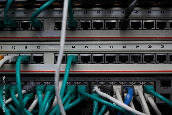 Fototapeta Inside of a server room. A lot of different cables in connectors. Equipment service in datacenter.