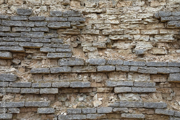 Fototapeta The brown and grey  cobblestone or brick tower, fortress or castle wall background or texture