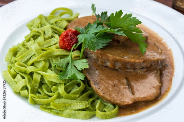 Obraz Roasted minced meat on rosemary creamsauce with spinach noodles