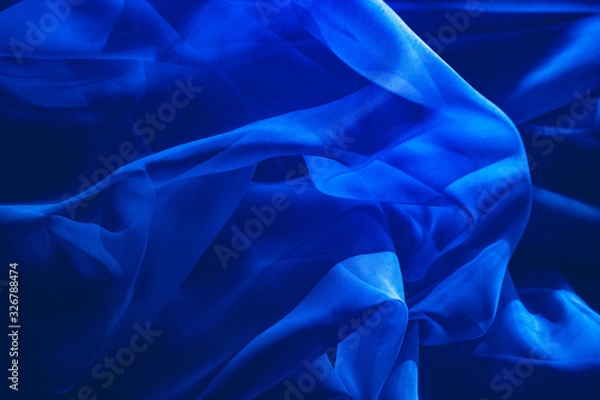 Fototapeta background image of a blue light translucent fabric with pleats. the view from the top.