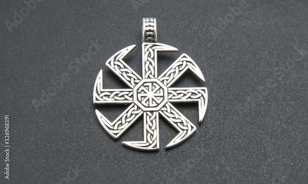Fototapeta Swastika. Slavic or Scandinavian amulet "Kolovrat" or the solstice "," Ladin "Pagan talisman, a symbol of the sun. On a black background. Close-up shot of excellent quality.