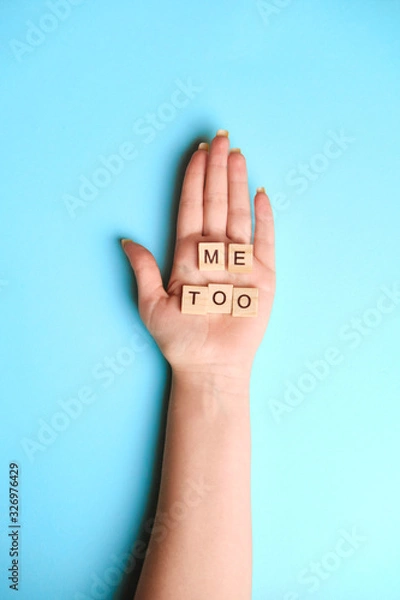 Fototapeta Phrase Me Too made of wooden letters in hand on blue background, top view. Stop sexual assault. Space left for text, copy