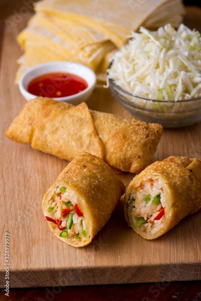 Fototapeta Eggrolls or Springrolls. Traditional Chinese, Thai or Japanese restaurant appetizer, fried. Made from wonton wrappers & filled with Chinese veggies and served w/ a chili dipping sauce or soy sauce.  