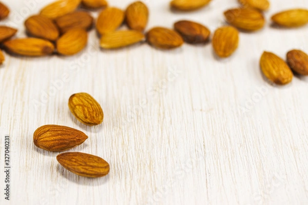 Obraz Almonds on a white wooden surface
