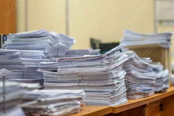 Fototapeta bundles bales of paper documents. stacks packs pile on the desk in the office