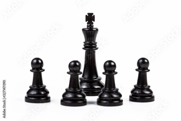 Obraz Black king chess piece surrounded by four pawns. People, group gathered around the ruler. Boss, leader, guru, authority, influence and crowd control, simple gathering and leadership abstract concept