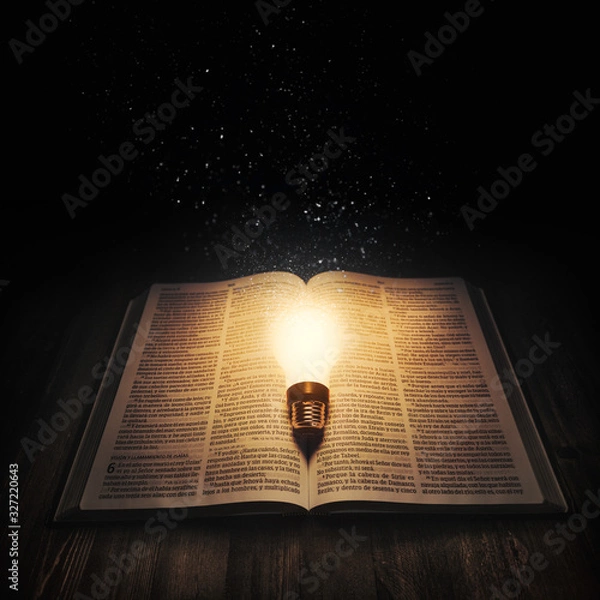 Obraz Light bulb lighting up an open bible