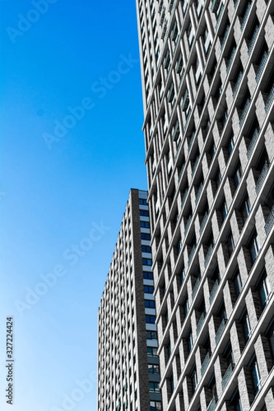 Fototapeta many Windows of a skyscraper. brick walls with Windows. Texture of a skyscraper against a blue sky