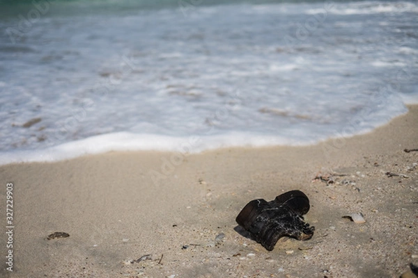 Fototapeta Garbage on the city beach. Pollution of the world's oceans with household waste, clothing and plastic. Territory of ecological disaster
