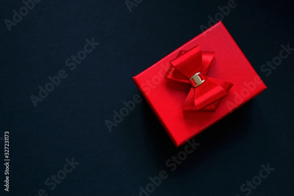 Fototapeta Red gift box with a red bow on a dark background