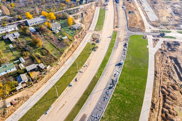 Fototapeta aerial top view on city construction site. construction of new highway at suburb area