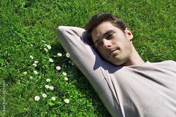 Fototapeta jeune homme triste déprimé rêveur dans l'herbe