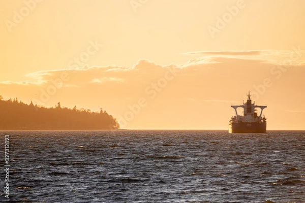 Obraz sunset on beach with rocks in the front and large  cargo boat near island  on water pacific ocean Pacific north west PNW Vancouver Canada boats waiting vertical photo 
