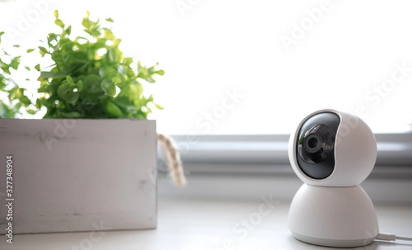 Fototapeta Indoor CCTV wireless IP security camera with 360 degrees rotating head, Concept of home security system for surveillance and protection, controlling via smartphone online.