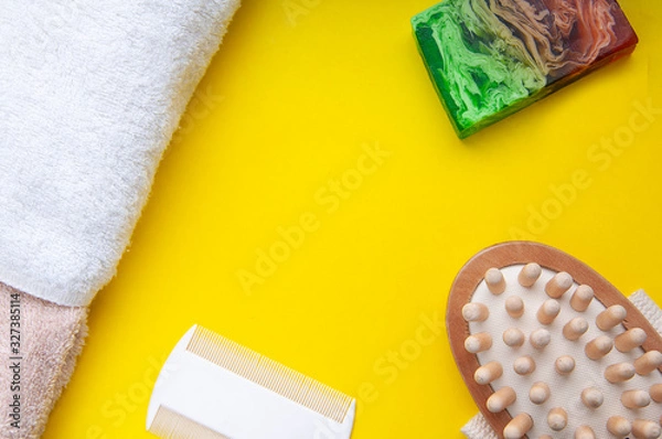 Fototapeta Bath accesories. Organic soap made from natiral ingredients. Comb and towel on a yellow background