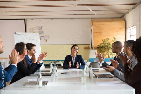 Fototapeta Subordinates applauding successful Asian speaker. Group of smiling business people during morning briefing. Business meeting concept