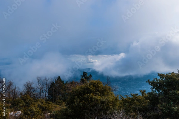 Fototapeta The panoramic view of Côte d'Azur Alps mountains under the cloudy sky and the Meditarrenean sea coastline in the horizon