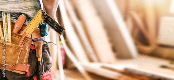 Obraz The carpenter with measuring and work tools in leather belt. Wide banner or panorama concept.